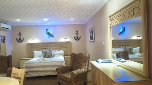 a hotel room with a bed and a mirror at Aark Guest Lodge in Vanderbijlpark