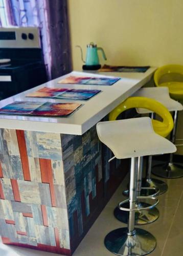 a kitchen with a counter with yellow stools at The Chill Spot in Mo Bay in Crooked River