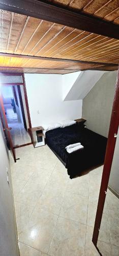 a small bed in a room with a wooden ceiling at Apartamento con terraza - Kalimalake in Darién