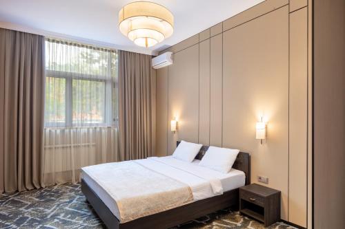 a bedroom with a bed and a large window at Rush Inn Hotel in Astana