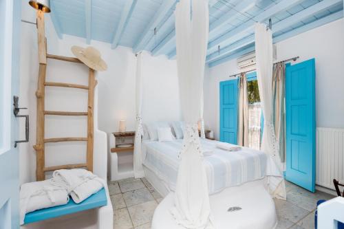 a white bedroom with blue doors and a bed at Belogna Ikons in Vívlos