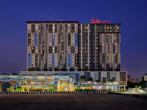 a hotel with a sign on top of a building at ibis Bangkok IMPACT in Nonthaburi
