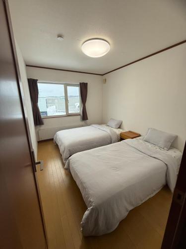 a room with two beds and a window at Gold rich 2 in Asahikawa