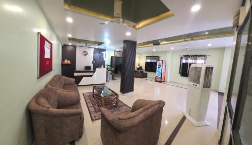 a living room with two chairs and a table at Hotel Balaji Inn in Raipur