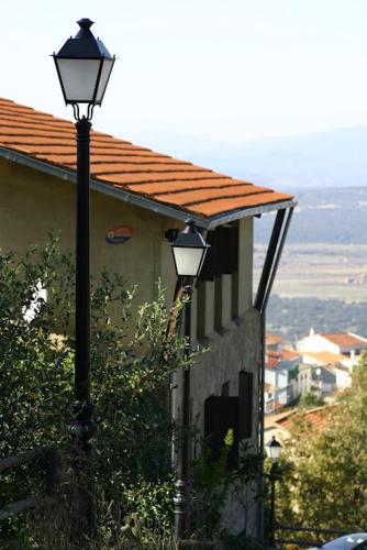 a street light next to a building with a roof at Albergue Aurora Boreal in Casas del Monte