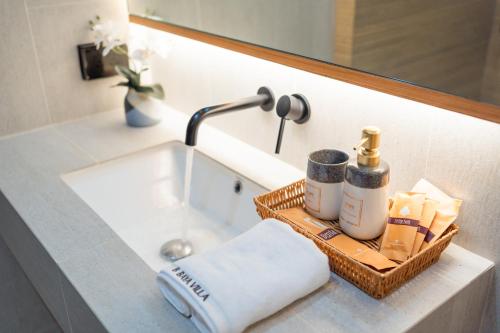 a bathroom sink with a towel and a mirror at Luxury B Baya Pool Villa in Ban Chong Phli