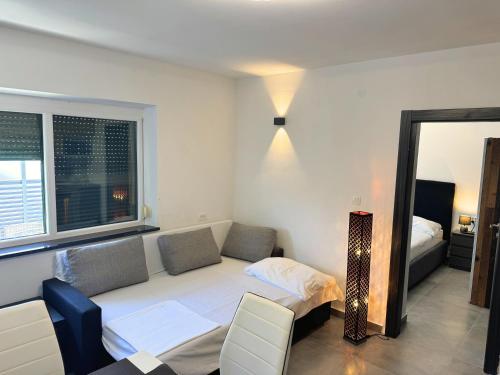 a room with a couch and a bed and a window at Paradise Villa Lopar in Lopar