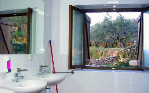 a bathroom with two sinks and a window at Albergue Aurora Boreal in Casas del Monte