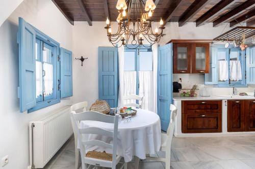 a kitchen with blue cabinets and a white table and chairs at Belogna Ikons in Vívlos