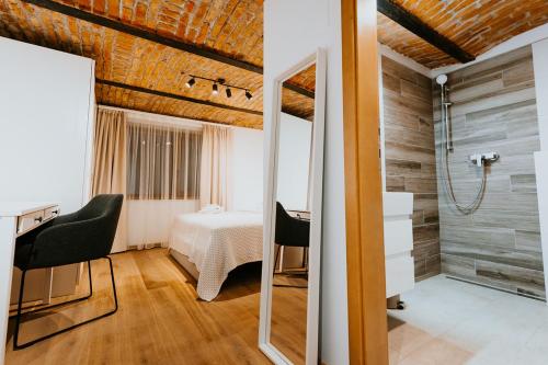 a room with a bed and a bathroom with a mirror at Lucy Villa in Băile Tuşnad