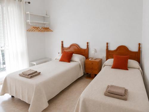 a bedroom with two beds and a window at Casa Paco & Carmela in Algodonales