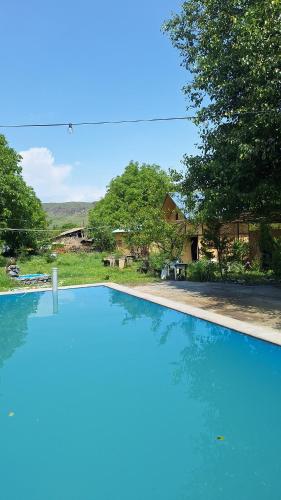 a large blue swimming pool in front of a house at Davti Toon Guesthouse in Aghitu