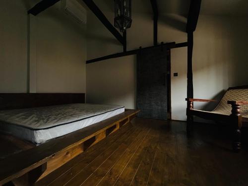 a room with a bed and a chair in it at La Terra Hirasawa in Shiojiri