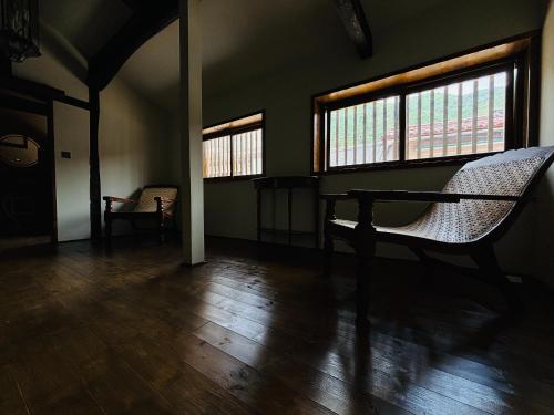 a room with two windows and a table and chairs at La Terra Hirasawa in Shiojiri