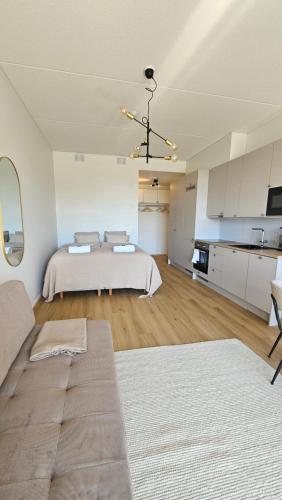 a large bedroom with a bed and a kitchen at Fabbrica's new and elegant apartment in Turku