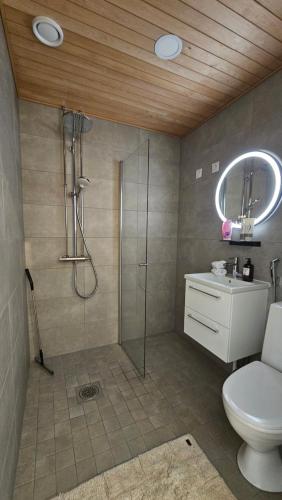 a bathroom with a shower and a toilet and a sink at Fabbrica's new and elegant apartment in Turku
