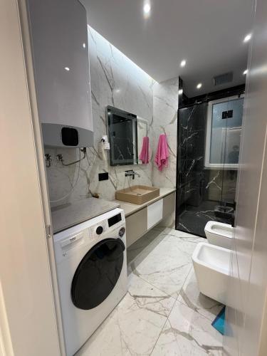 a white bathroom with a sink and a toilet at Merxhan`S Apartment in Golem