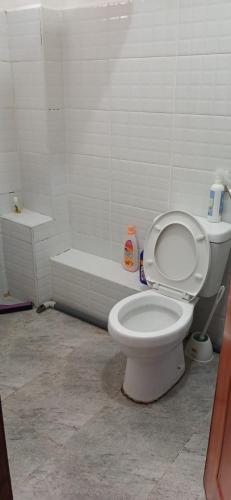 a bathroom with a toilet and a bath tub at Sunny Studio Kikuyu Town in Kikuyu