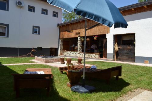 a patio with a table and an umbrella in the grass at Lakuša Retreat in Latin