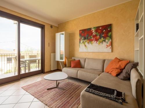 a living room with a couch and a table at Snug Holiday Home in Lazise with Heating, near Lake Garda in Lazise