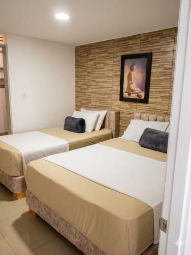 a bedroom with two beds in a room at Hotel Iam Armenia Quindio in Armenia