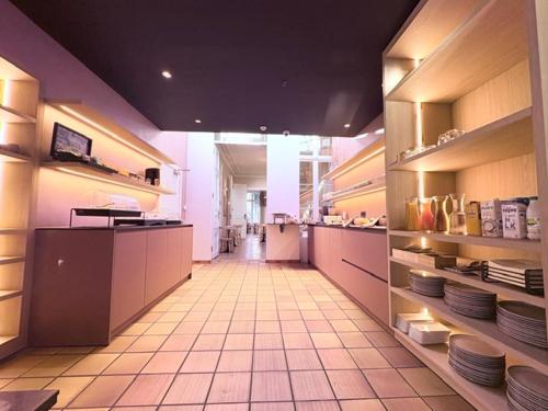 a large kitchen with plates on shelves in a kitchen at Parkhotel Gent Centrum in Ghent