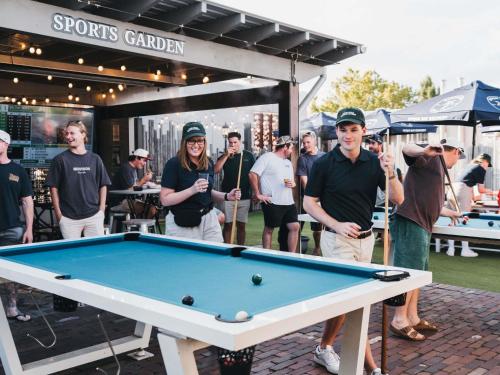 a group of people standing around a pool table at Mercure Orange in Orange