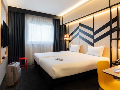 a hotel room with a large bed and a window at ibis Styles Geneve Palexpo Aeroport in Geneva