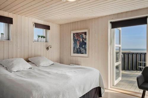 a bedroom with a white bed and a balcony at OH451-Hadsund-Haslevgaarde-Bakker-72 in Hadsund