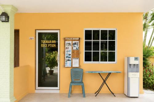 a blue chair sitting outside of a yellow building at Collection O Langkawi Near Pantai Cenang formerly Tokman Inn in Pantai Cenang