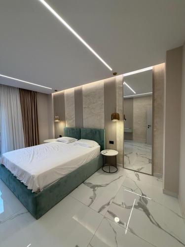 a bedroom with a large bed and a bathroom at Merxhan`S Apartment in Golem