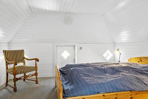 a bedroom with a bed and a chair in it at LF10211-Thyholm-Ronbakken-11 in Thyholm
