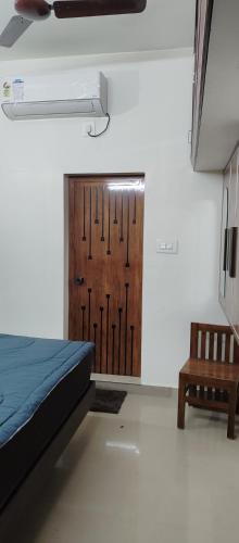 a room with a bed and a wooden door at Ocean wings Traditional beach villa in Kaipamangalam