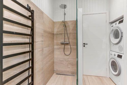 a bathroom with a shower and a washer and dryer at BV383-Blavand-Toldbodvej-34 in Blåvand