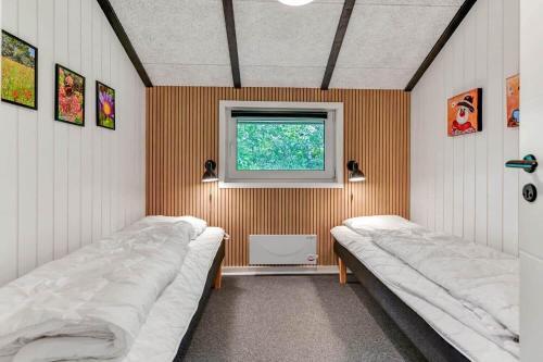 two beds in a small room with a window at BV383-Blavand-Toldbodvej-34 in Blåvand