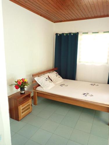 a small room with a bed and a window at La maison jaune in Nosy Be