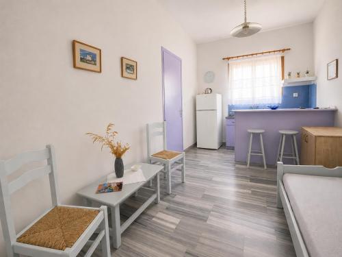 a kitchen with a refrigerator and a table and chairs at Stelios Zalonis Apartments in Tinos