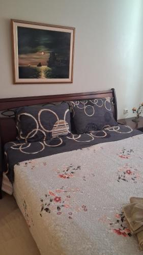 a bedroom with a bed with a picture on the wall at MARIOS HOUSE 1 in Xanthi