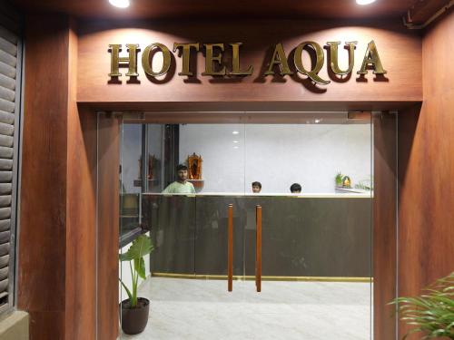 a hotel aura sign over the entrance to a building at Hotel Aqua in Rajkot