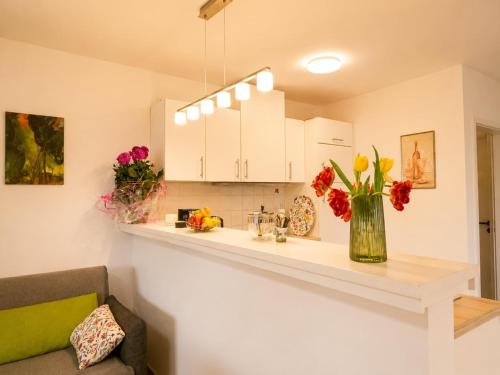a kitchen with a counter with flowers in a vase at Zur Kapellenwiese in Oberthal