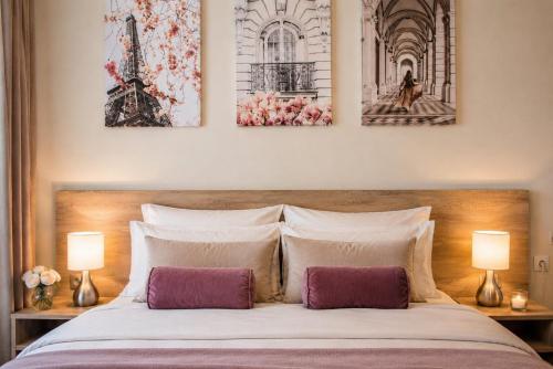 a bedroom with a bed with three pictures on the wall at Galaxy Apartments in Belgrade