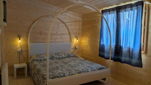 a bedroom with a bed in a wooden cabin at Camping Yoghi e Bubu in San Giacomo
