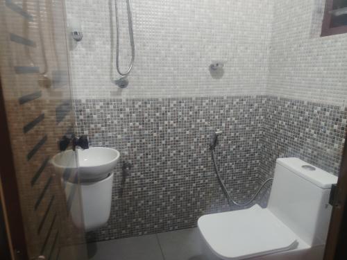 a bathroom with a toilet and a sink at Ocean wings Traditional beach villa in Kaipamangalam