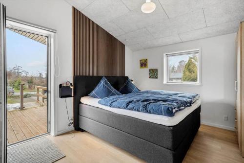 a bedroom with a large bed and a sliding glass door at SL343-Slagelse-Bygvangen-7 in Strandlyst