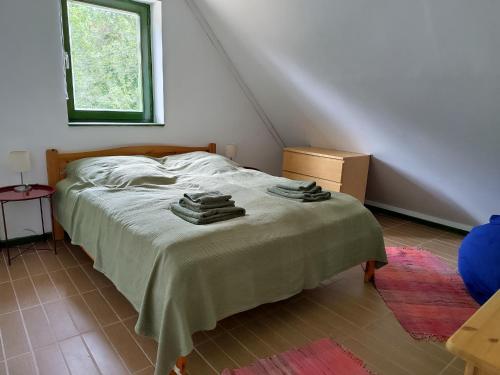 a bedroom with a bed with towels on it at Mackó Kuckó Verőce in Kismaros