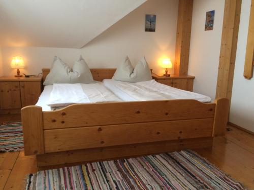 ein Schlafzimmer mit einem großen Bett mit weißer Bettwäsche und Kissen in der Unterkunft Biohof Sauschneider in Sankt Margarethen im Lungau