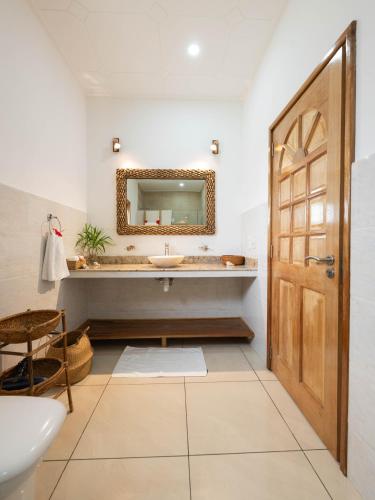 a bathroom with a sink and a mirror at Maison Ed-Elle in La Digue