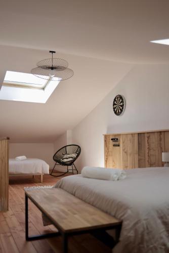 a bedroom with two beds and a clock on the wall at Cozy Apartment in Pontgibaud