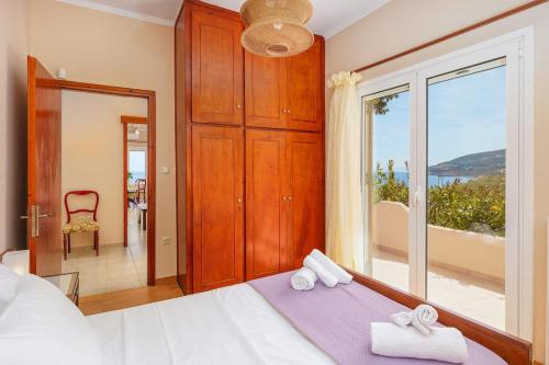 a bedroom with a bed and a large window at Haris House in Dhaskalión