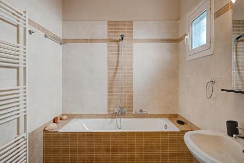 a bathroom with a tub and a sink at Haris House in Dhaskalión